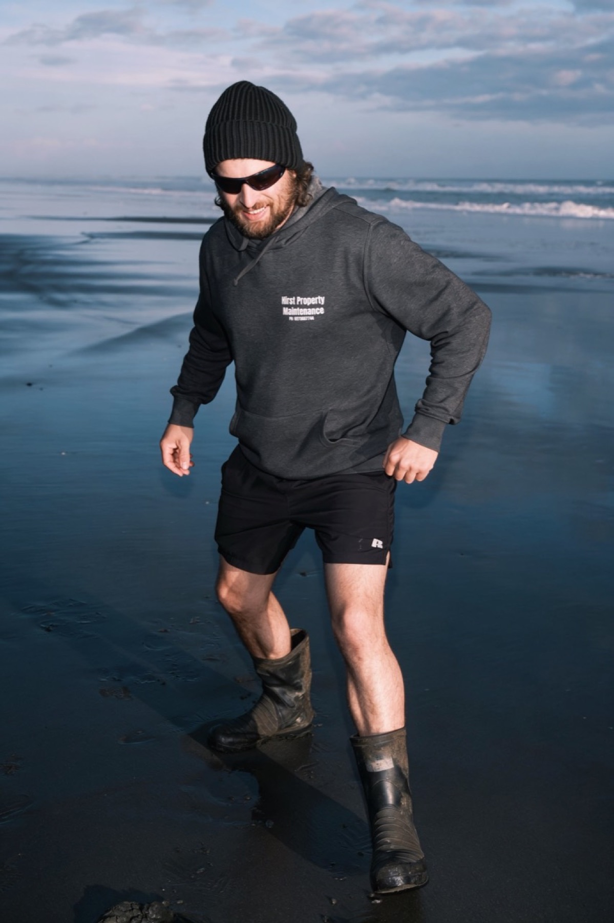 Maintenance worker walking along a beach in work clothes