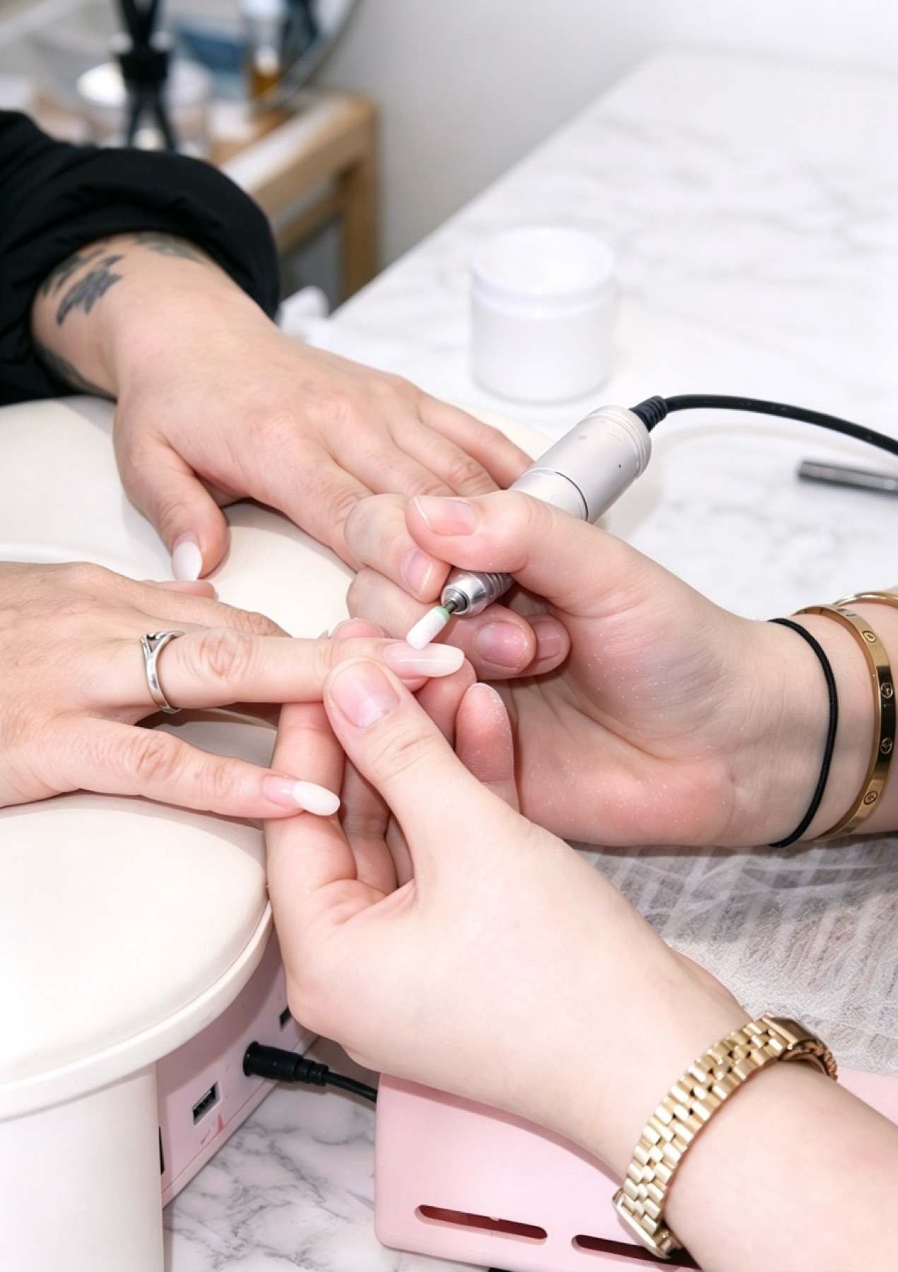 Close-up of a nail technician shaping a client’s nail
